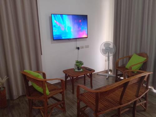sala de estar con sillas y TV en la pared en PLAYA Y CAMPO EN UN SOLO LUGAR, en Olón