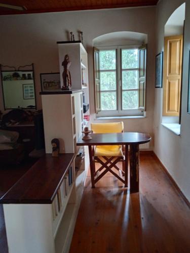 a kitchen with a table and a yellow chair at Alegria house with gardens near portoheli in Kranidi
