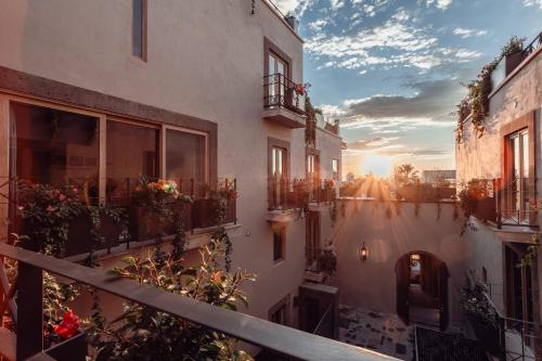 uma vista para uma varanda de um edifício com o pôr-do-sol em Le Cottage San Miguel de Allende, Modern Luxury in Centro with Pool & Jacuzzi em San Miguel de Allende