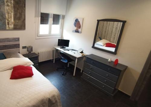 a bedroom with a desk and a bed and a mirror at OUH Candy Box in Bilbao