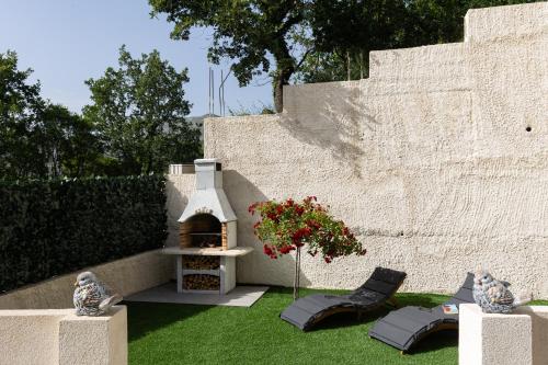a backyard with a pizza oven in the grass at Luma Retreat Jacuzzi & Peaceful Rides in Petrača