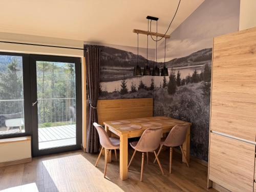 Český JiřetínにあるFláje Apartmányの木製のテーブルと椅子のあるダイニングルーム