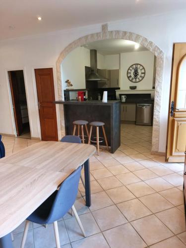 une grande cuisine avec une table et des chaises en bois dans l'établissement Appartement cosy tout confort, à Mâcon