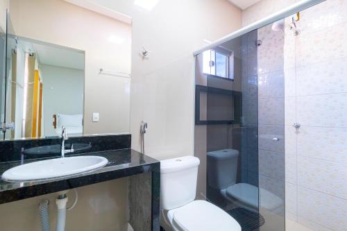 a bathroom with a toilet and a sink and a shower at Pousada Meia Lua in Pirenópolis