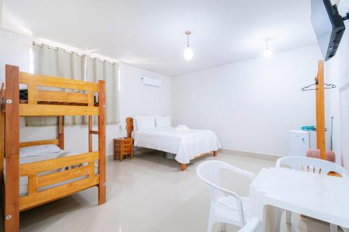 a bedroom with a bunk bed and a bed and a table at Pousada Meia Lua in Pirenópolis
