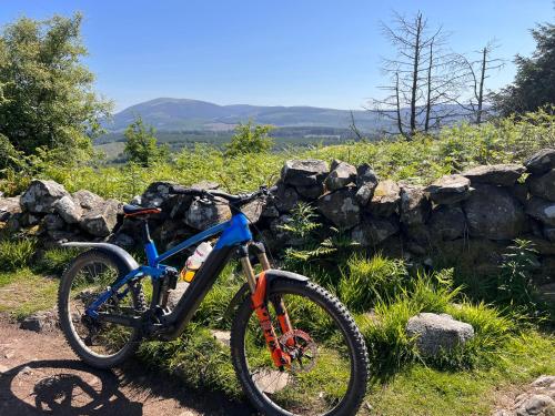 a bike parked next to a stone wall at Woodlane lodge with private Hottub & Pool table in Dumfries