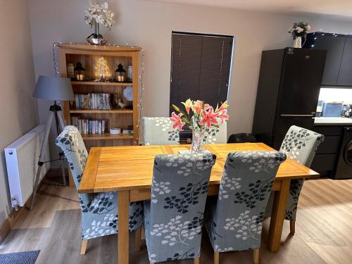 a dining room with a wooden table and chairs at Woodlane lodge with private Hottub & Pool table in Dumfries