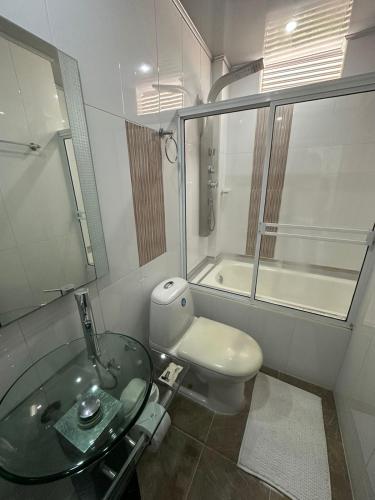 a bathroom with a glass sink and a toilet at Hotel Real De Minas in El Paso