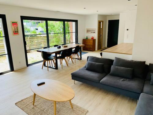 un salon avec un canapé et une table dans l'établissement Très belle maison au calme entre centre et plages, à Capbreton