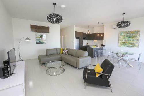 a living room with a couch and a table at Indulge Apartments - CBD in Mildura
