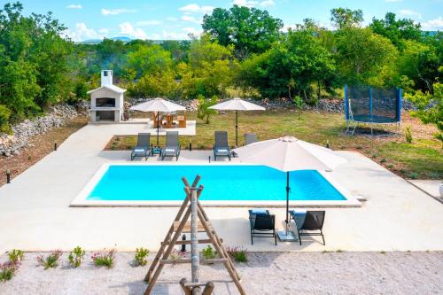 an overhead view of a pool with chairs and umbrellas at Villa Lea&Robi in Unešić