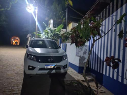 a white car parked next to a wall at night at Casa Bananeiras Tunel in Bananeiras