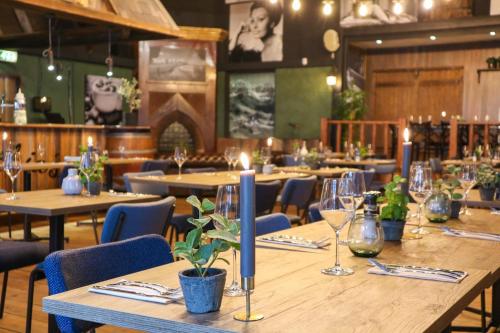 a dining room with wooden tables and blue chairs at Tiny House op de Veluwe in Beekbergen