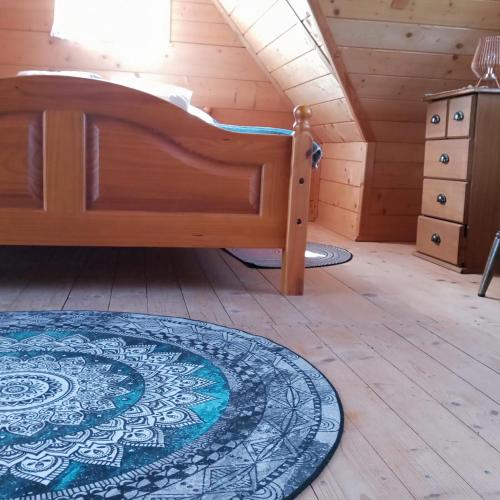 a bedroom with a bed and a rug in a attic at Sielanka na wzgórzu in Czostków