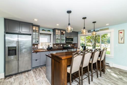 a kitchen with stainless steel appliances and a wooden table at Chelsea Lake House, Game Room, & Pontoon-rental in Chelsea