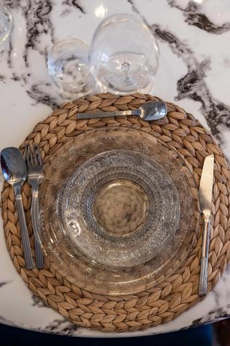 a glass plate on a table with glasses and utensils at L'Etoile - Duplex cosy de 50m2 en centre-ville in Nîmes