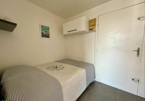 une petite chambre avec un lit et un placard dans l'établissement Double studio cabine Grau du Roi, au Grau-du-Roi