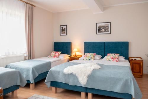 シャフラリにあるWILLA ANNA - 20 procent Termy Gorący Potokのベッドルーム1室(青いヘッドボード付きのベッド2台付)
