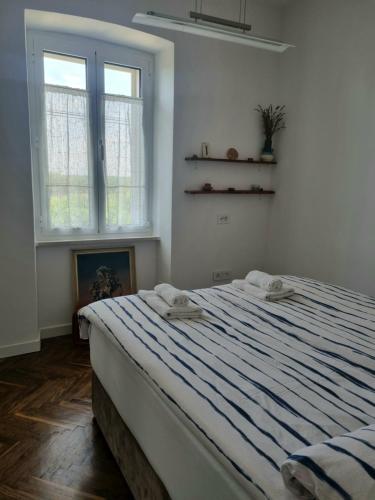 a bedroom with a large bed with a blue striped blanket at Apartment Eufemia in Kanfanar
