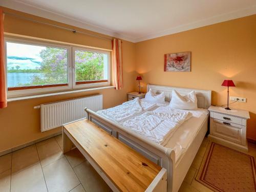 ein Schlafzimmer mit einem großen Bett und einem Fenster in der Unterkunft Ferienhaus Seemannsruh Wohnung mit Wasserblick und abgeschlossenem Grundstück in Marienfelde