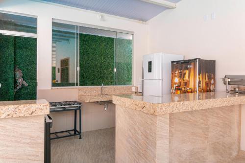 a kitchen with a counter top and a refrigerator at Pousada Meia Lua in Pirenópolis