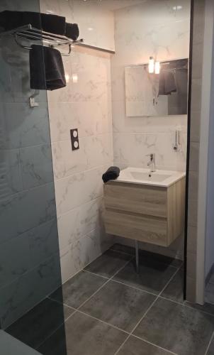 a bathroom with a sink and a shower at Au Complex By Suprême in Laboutarié