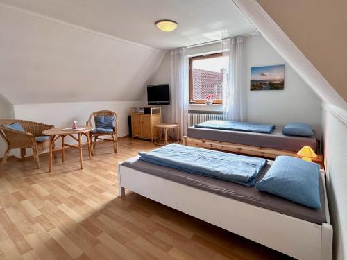 a bedroom with two beds and a table and chairs at Ferienhaus Pfänderblick in Rickenbach