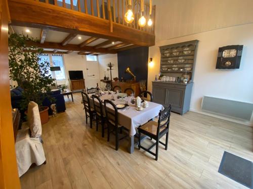 une salle à manger avec une table et des chaises blanches dans l'établissement La maison des vacances chez Geneviève & Norbert 6 à 8 personnes, à Les Sables-dʼOlonne