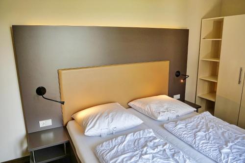 un letto con due cuscini sopra in una stanza di Resort Deichgraf Resort Deichgraf 31-12 a Wremen