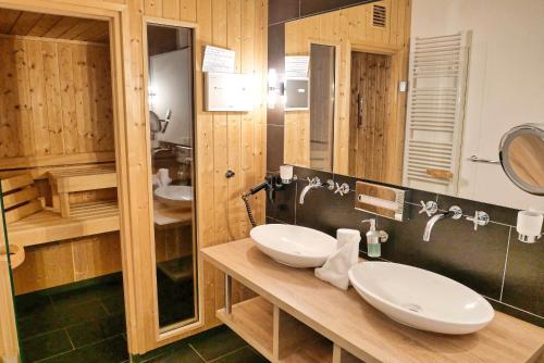 a bathroom with two sinks on a wooden counter at Resort Deichgraf Resort Deichgraf 31-12 in Wremen