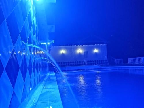 a swimming pool at night with blue lights at Hotel Bellavista Isla del Sol in Prado
