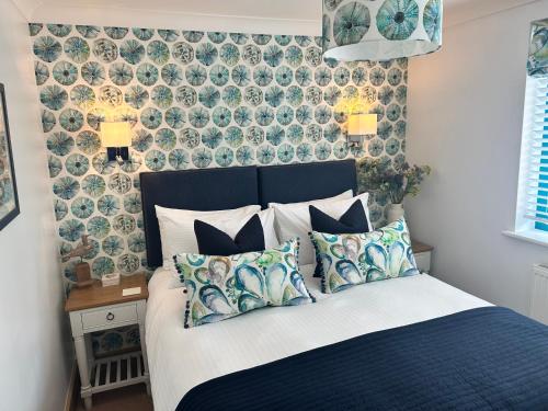 Un dormitorio con una cama azul con almohadas. en Crabshell Quay waterfront living in Kingsbridge, en Kingsbridge