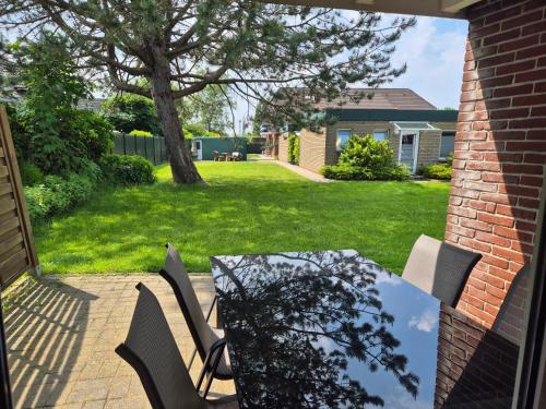 a table and chairs on a patio with a yard at Ferienhaus Herzmuschel in Norddeich