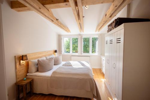 ein Schlafzimmer mit einem Bett in einem Zimmer mit Holzdecken in der Unterkunft Ferienanlage Landliebe Ferienhausteil 15 in Alkersum