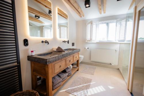 ein Badezimmer mit Waschbecken und Spiegel in der Unterkunft Ferienanlage Landliebe Ferienhausteil 15 in Alkersum