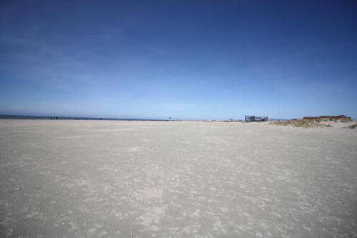 a sandy beach with a blue sky in the background at Ferienhaus Herzmuschel in Norddeich