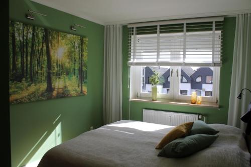 a green bedroom with a bed and a window at fewo1846 - Promenade Wassersleben in Harrislee