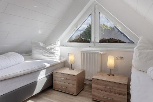 sypialnia z łóżkiem, 2 lampami i oknem w obiekcie 50046... w mieście Carolinensiel