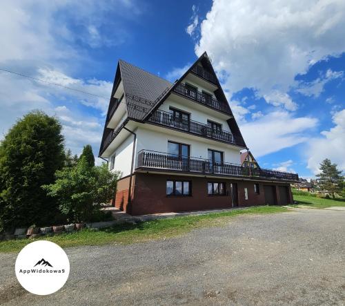 a large house with a gambrel roof at Apartament z widokiem na panoramę Tatr "AppWidokowa9" in Gliczarów Górny