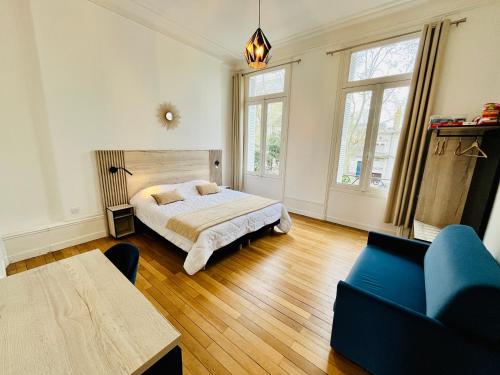 une chambre avec un lit et un canapé bleu dans l'établissement Hypercentre, spacieux, familial, lumineux, l'Elegant, à Tours