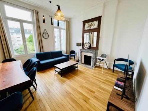 un salon avec un canapé bleu et une cheminée dans l'établissement Hypercentre, spacieux, familial, lumineux, l'Elegant, à Tours