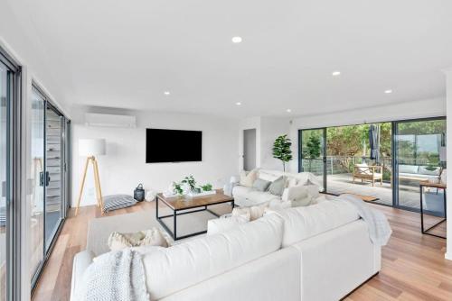 a white living room with a large white couch at Seafarers Horizon oceanfront retreat in Ocean Grove