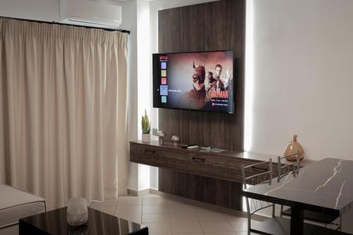 een woonkamer met een flatscreen-tv aan de muur bij Cervantes Nafpaktos in Nafpaktos