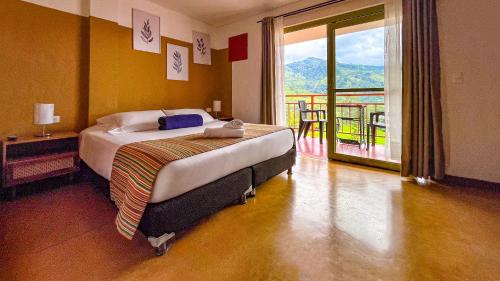 a bedroom with a bed with a view of a balcony at Viajero Salento Hostel in Salento