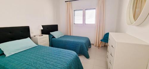 a bedroom with two beds and a mirror at Apartamento de la Playa II in Tías