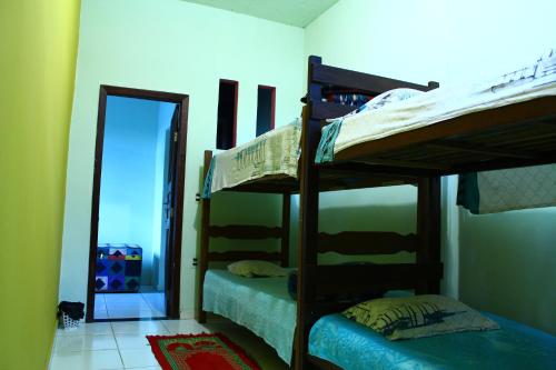 2 łóżka piętrowe w pokoju z lustrem w obiekcie HOSTEL Divinópolis w mieście Divinópolis