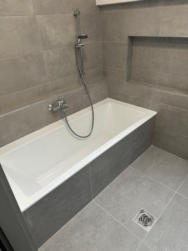 a bathroom with a bath tub with a shower at Hullám Panorama & Jacuzzi in Balatonlelle