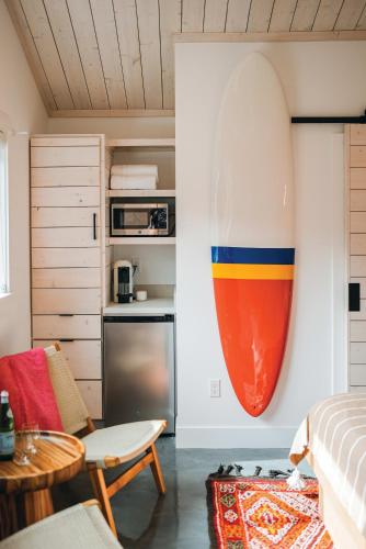 a large surfboard on the wall of a bedroom at Funboard Room includes King Bed and Mini Kitchenette in Stinson Beach