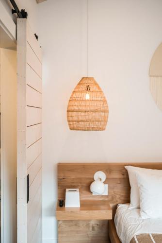 een slaapkamer met een bed en een hanglamp bij Funboard Room includes King Bed and Mini Kitchenette in Stinson Beach