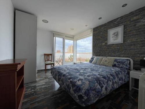 Un dormitorio con una cama y una pared de ladrillo. en Ático con vista al Mar Menor, en Santiago de la Ribera